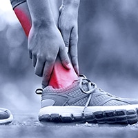 new-services-foot-pain Woman holding ankle indicating foot pain