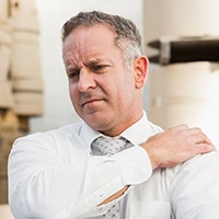 new-services-shoulder-pain Man holding shoulder indicating shoulder pain