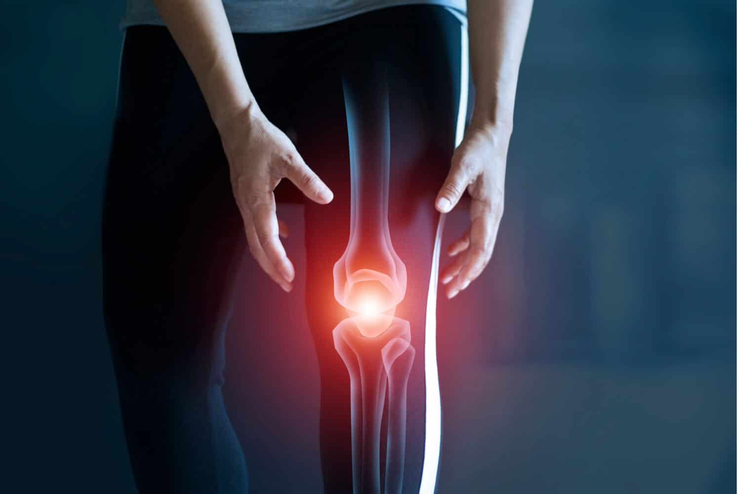 knee-injury Person holding their knee with a digital overlay showing internal knee joint and red glowing area indicating pain or injury.