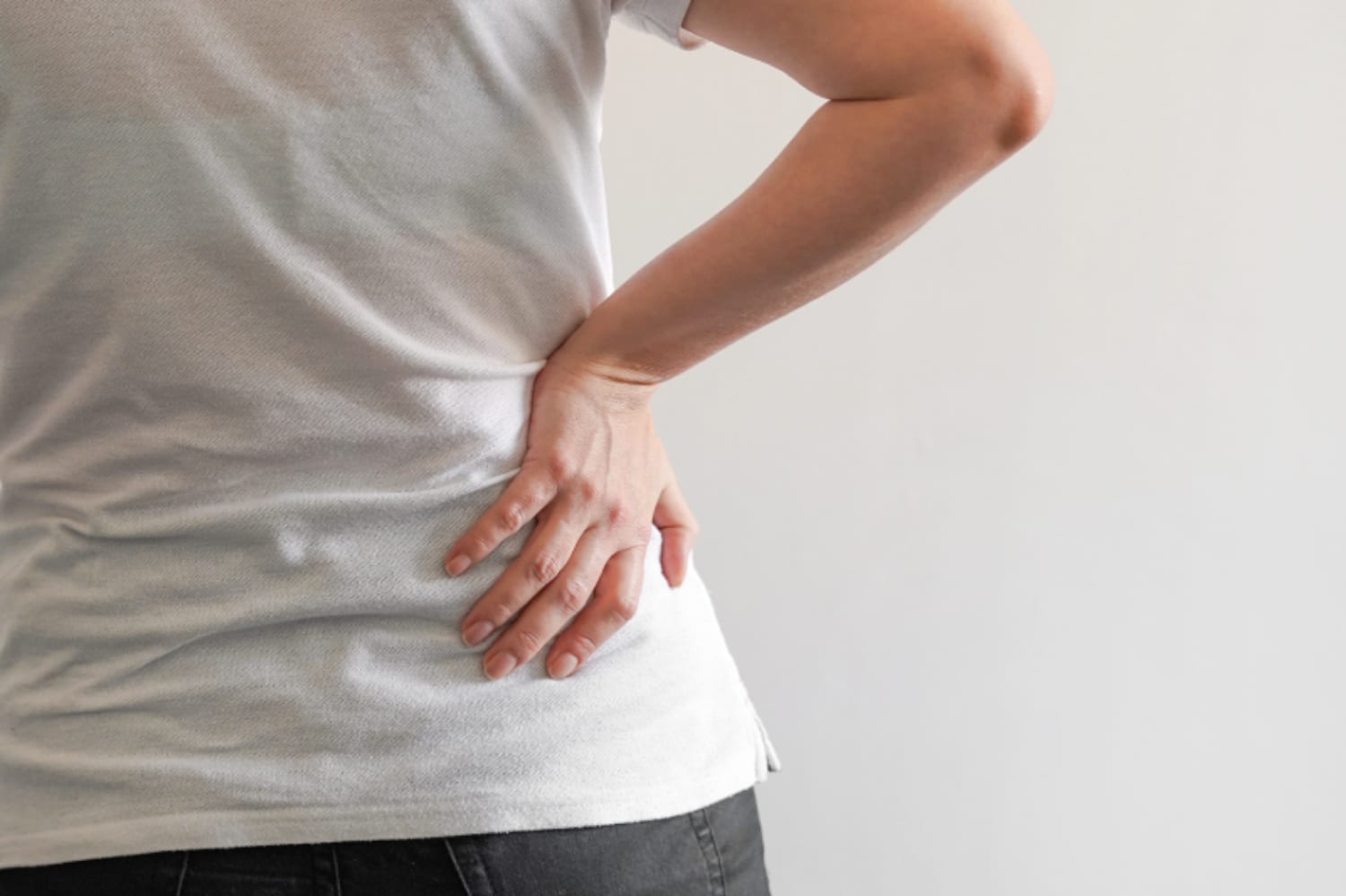 Physical Therapy for Sciatica: Your Path to Relief Closeup of a woman holding her lower back in pain.