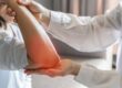 Physical therapist exams elbow of physical therapy patient with arthritis pain.