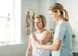 Female physical therapist helping a female patient stretch.