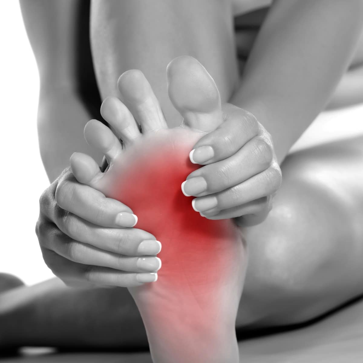 Person holding foot with highlighted red pain area, indicating foot pain or discomfort.